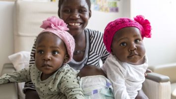 Acen (left) and Apio (right) Akello arrived at Nationwide Children`s Hospital conjoined as one and were separated during a 16-hour surgery on Sept. 3, 2015. The tissue expanders were placed in between them underneath their skin to prepare for separation. The girls are pictured here in their hospital room with their mother, Ester Akello.