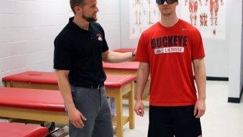 Dustin Grooms, PhD, ATC, CSCS, left, uses shutter glasses while working to rehab the knee of Scott Monfort. The glasses create a visual distraction, which causes patients to rely more on instinct during rehabilitation and less on visual cues, which often happens to patients who suffer knee injuries, a new study shows.