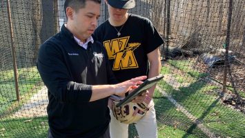 Jeremiah Cangelosi (right) reviews video of himself pitching with athletic trainer, Michael Macatangay. Being able to freeze the video and analyze the angles of his arm and body has helped Jeremiah make corrections to his throwing style to improve accuracy and prevent injuries.