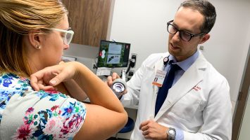 Doctor Benjamin Kaffenberger examines a psoriasis patient at The Ohio State University Wexner Medical Center. He led a study that found healthy lifestyle changes, such as practicing good dental hygiene and eating fruit every day, may help improve psoriasis symptoms.